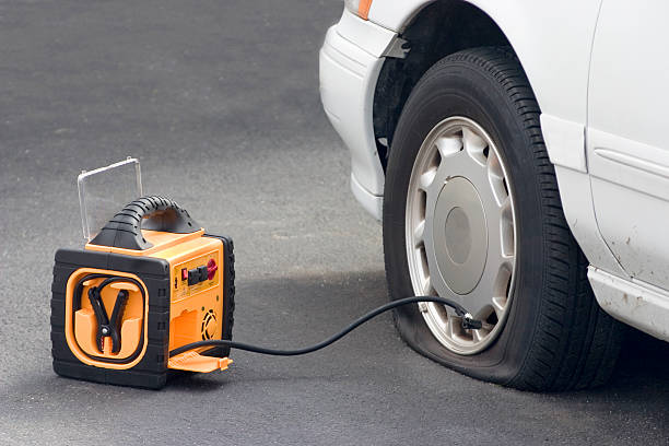 a flat tire is tended to by a portble air compressor